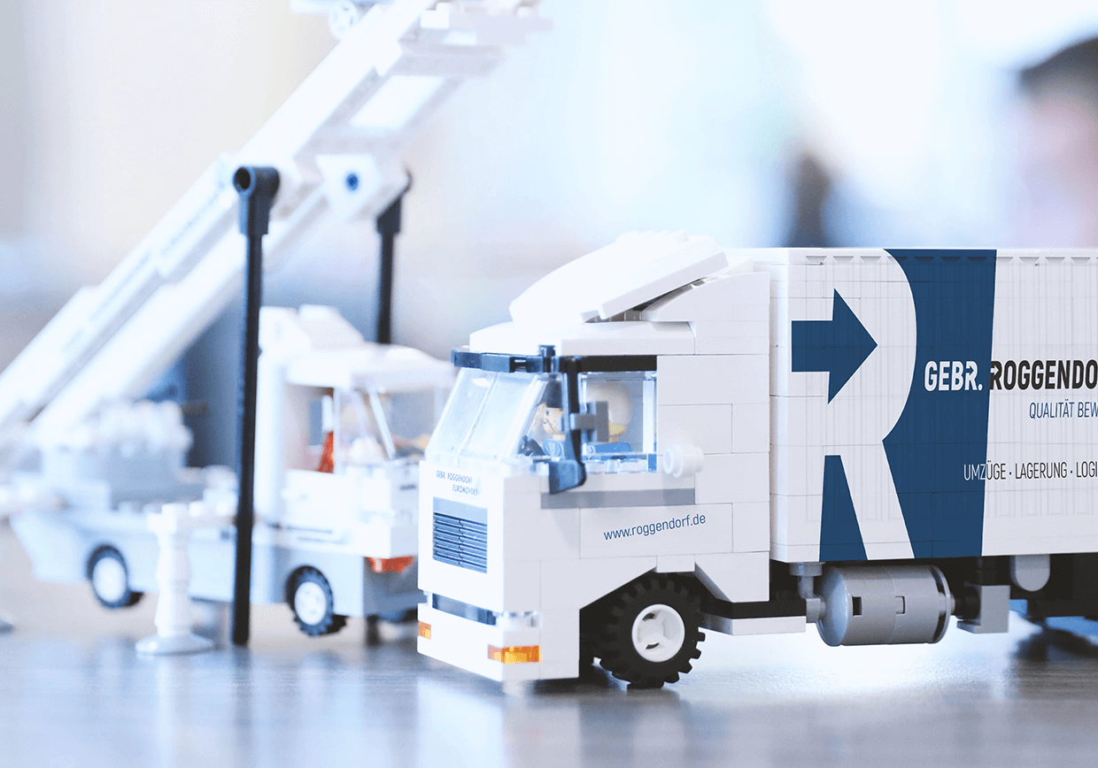 Nahaufnahme von weißen und blauen LEGO-Spielzeug-Lkw auf einem Tisch, Hintergrund unscharf.